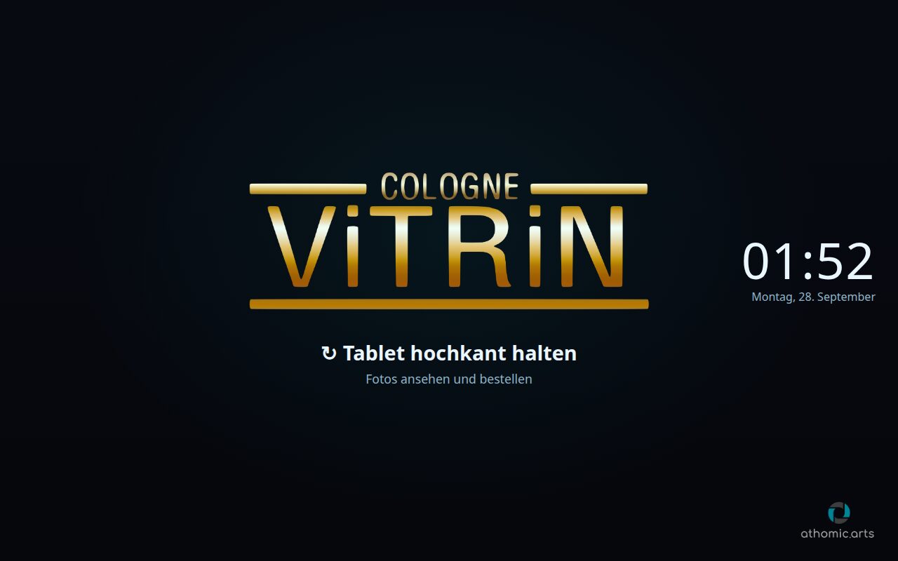 Tablet im Querformat: Ruhebild mit dem Logo des Saals und Uhr